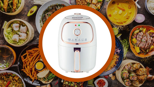 A white and small size air fryer surrounded by various dishes on a wooden surface.